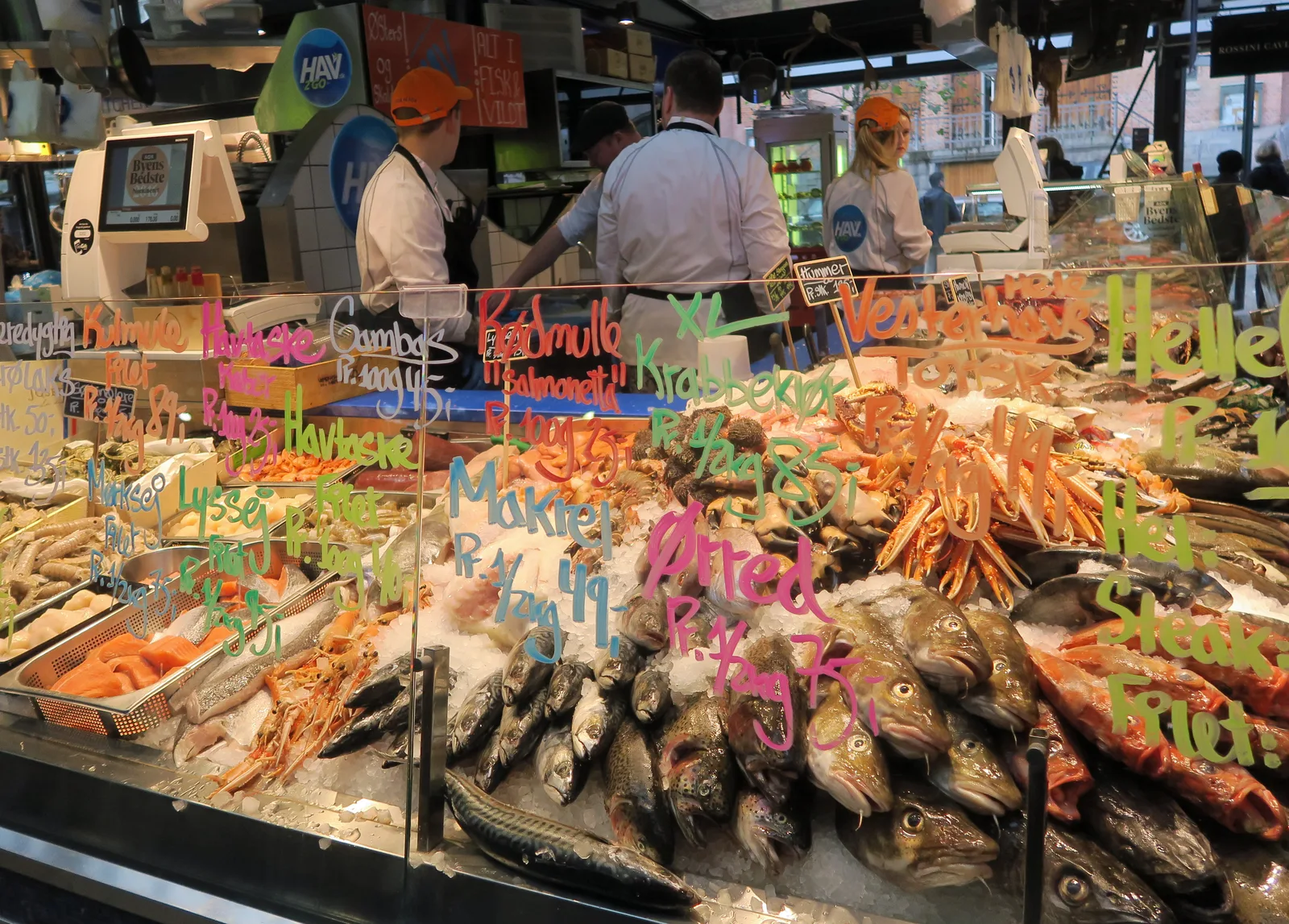 Copenhagen food hall with diverse cuisine vendors and local diners enjoying affordable meals
