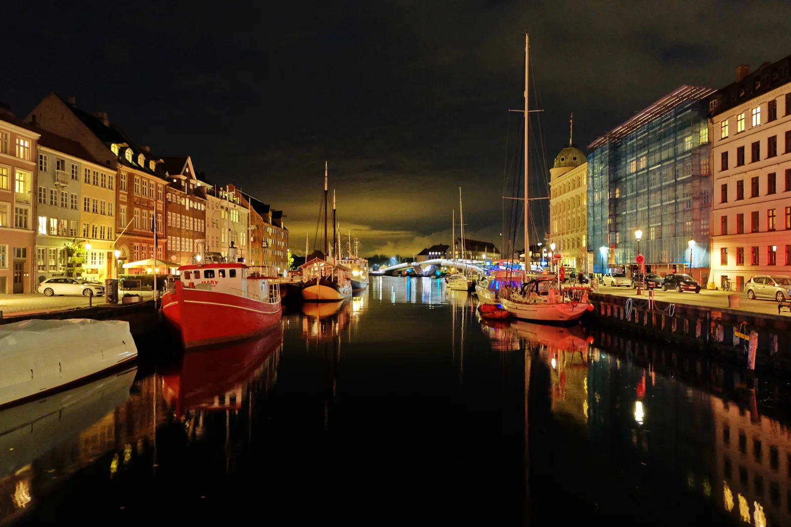 Colourful historic townhouses of Nyhavn in Copenhagen with spring light reflecting off the water