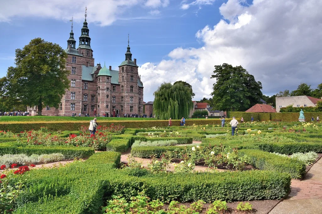 Rosenborg Castle exterior with red brick facade surrounded by green gardens in Copenhagen